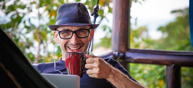 A man working remotely while drinking a cup of beverage.