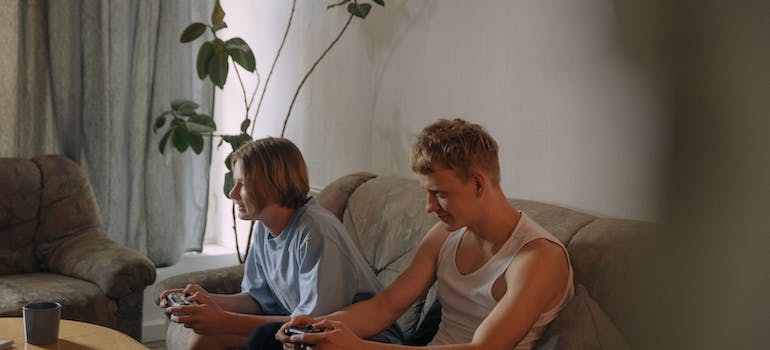 A Young Boys Sitting on the Couch while Playing Videogame.