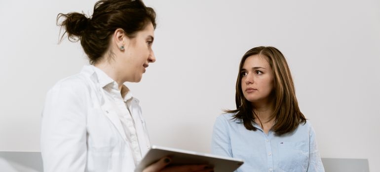 Pregnant woman discussing alcohol and pregnancy with a doctor during a consultation.