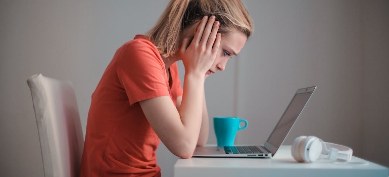Worried young woman sitting in front of a laptop. 