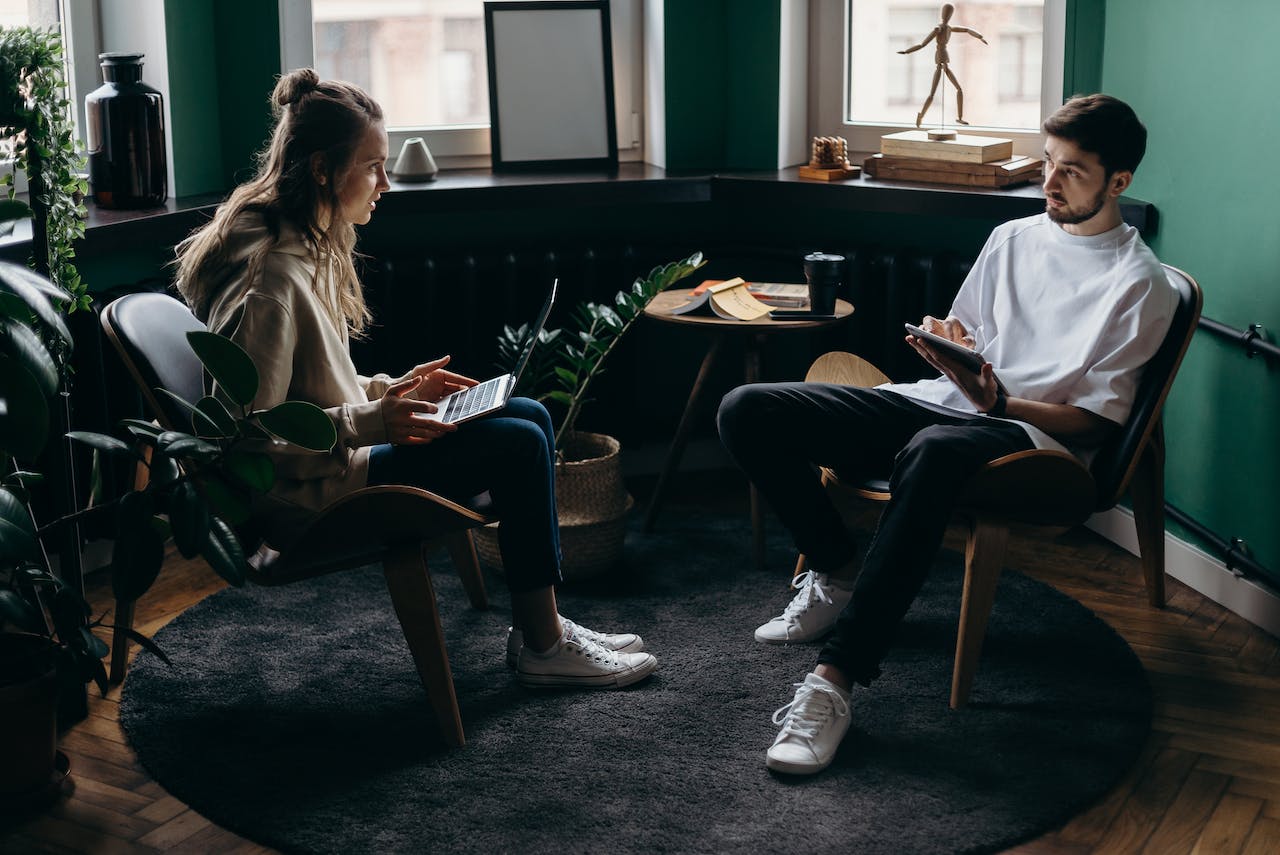 A man and woman are talking to each other about family members of addicts.