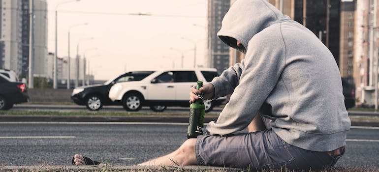 person drinking on the side of the road.
