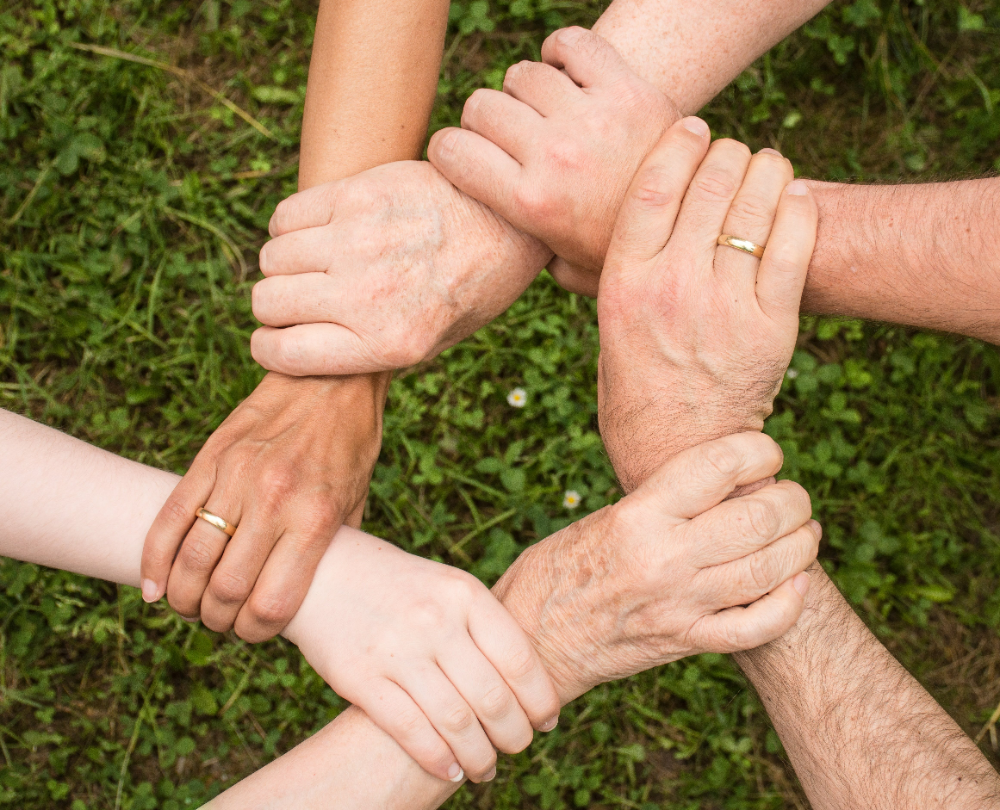 six hands of support holding each other repersenting Newburgh NY residents choose Pennsylvania's Little Creek