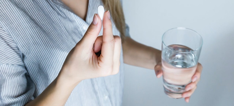 A person taking medicine with water after rehab in Allentown PA has to offer. 