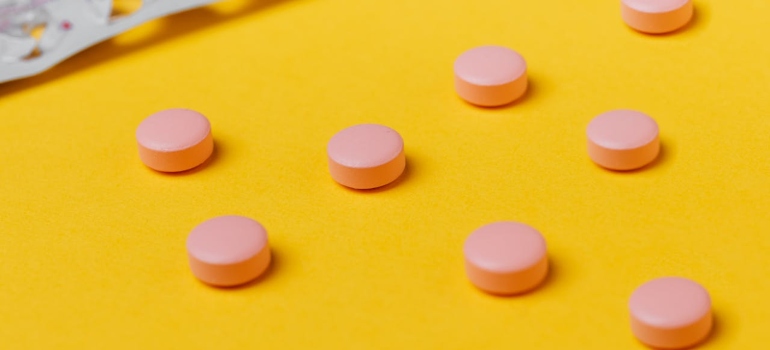 pink pills on yellow surface 