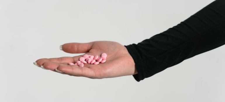 a woman holding medicines in her hand 