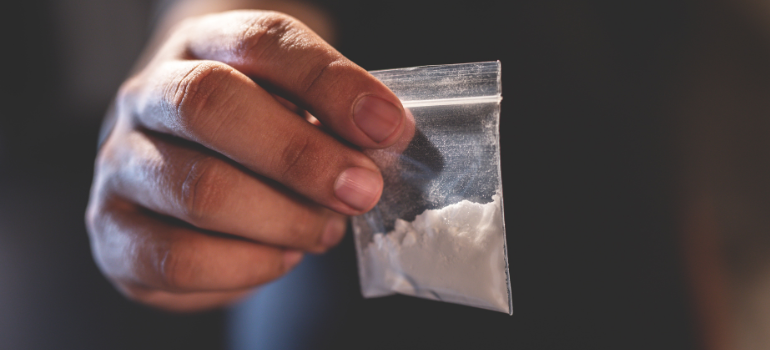 a person holding a bag with white powder wondering how long does heroin stay in your system