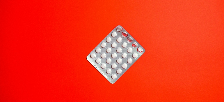 White pills on a red background for managing pain relief with Tramadol