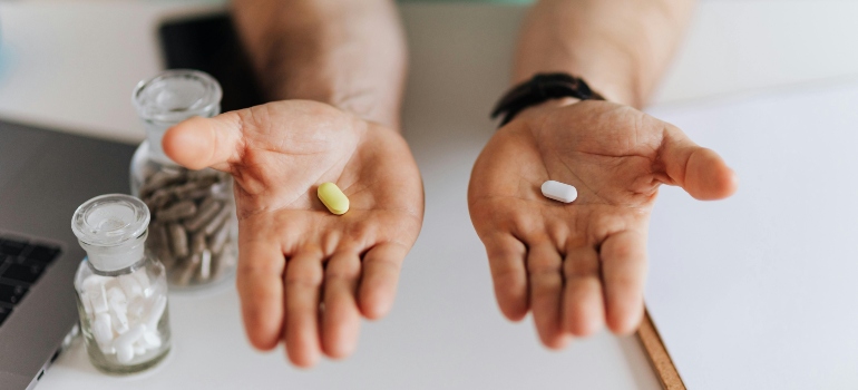 A person holding a pill in each palm