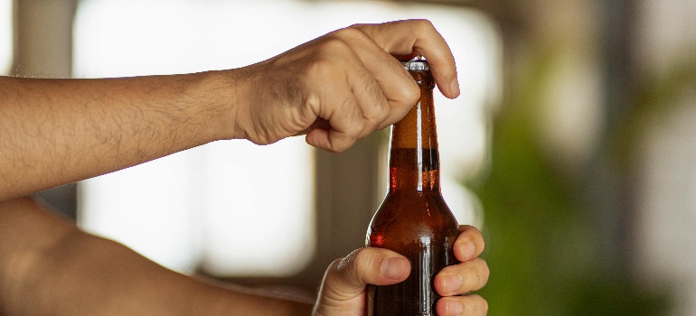 a person opening a beer 