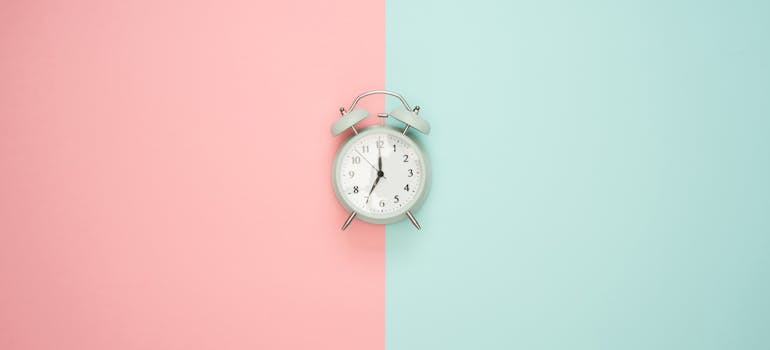 alarm clock in front of a pink and blue background