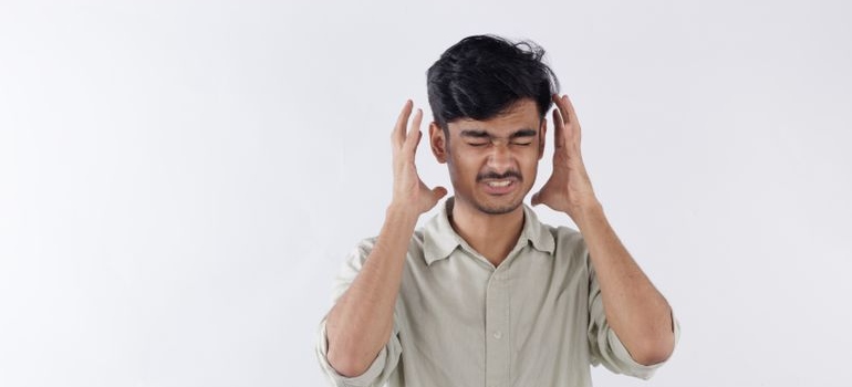 Angry man trying to grab his head.
