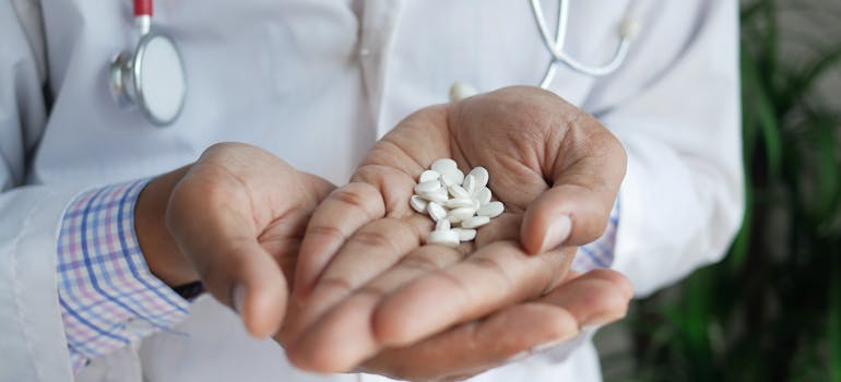 Doctor holding white pills in his palms wondering if benzos cause dementia