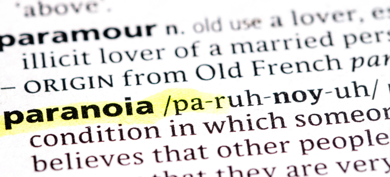 The dictionary definition of paranoia highlighted in yellow in a dictionary