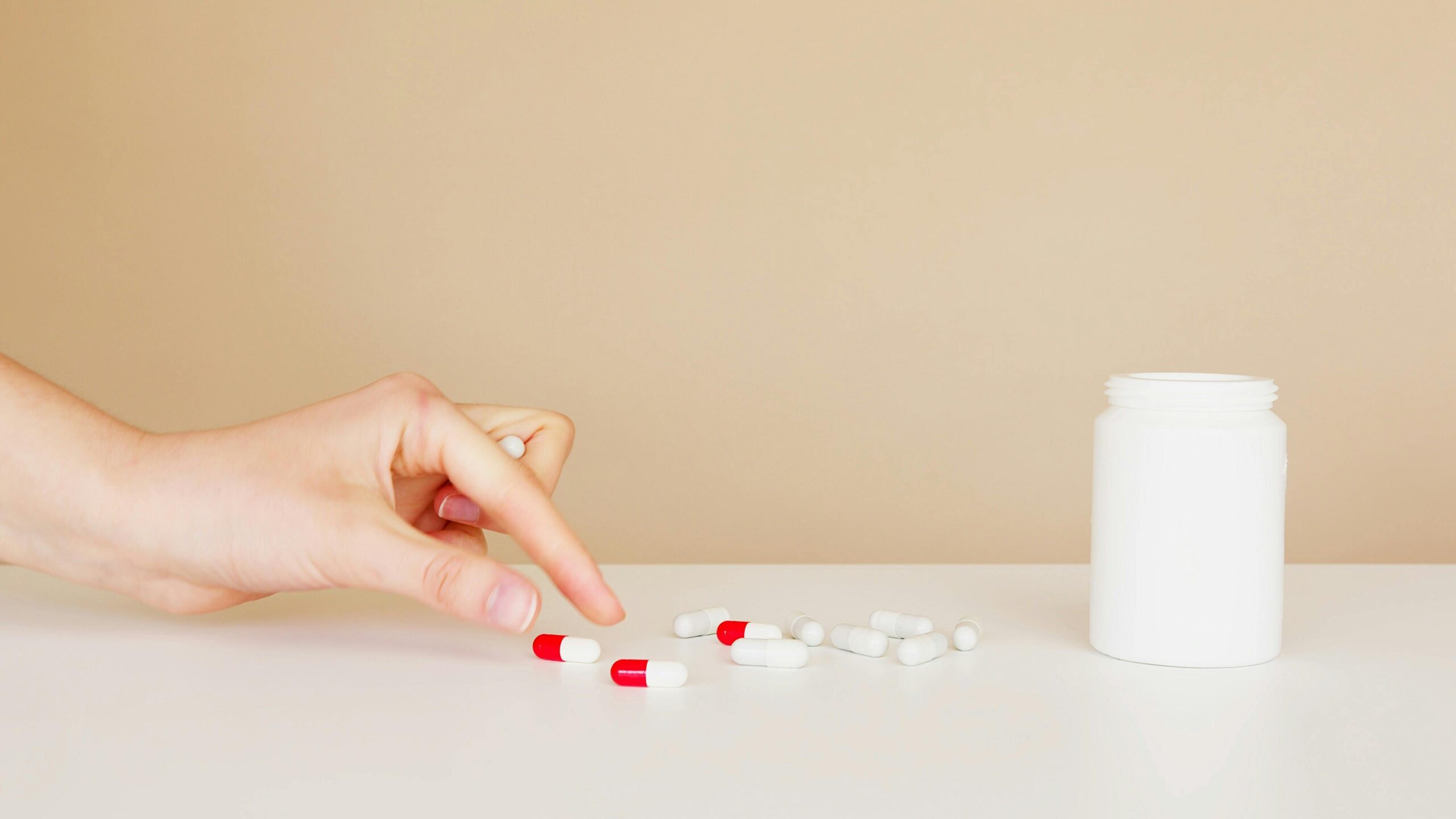 a person picking up a pill from the table