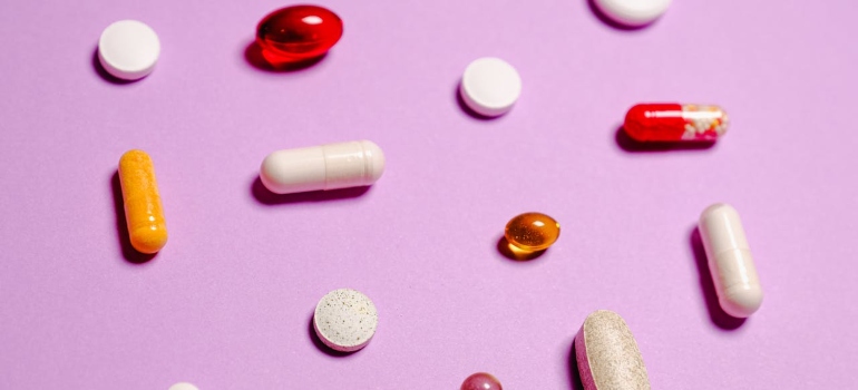 a lot of different pills on a pink surface 