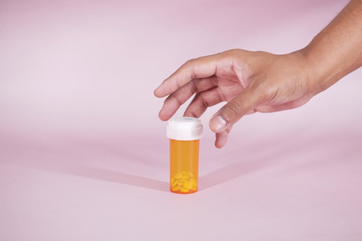 a person reaching for a bottle of pills wondering does valium show up on a drug test