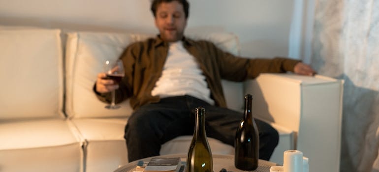Man drinking wine on his couch.