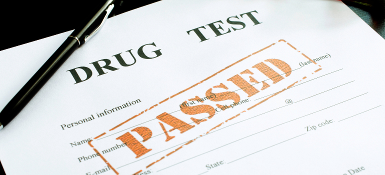 A printed paper reading drug test with a red passed seal and a black pen on the side.
