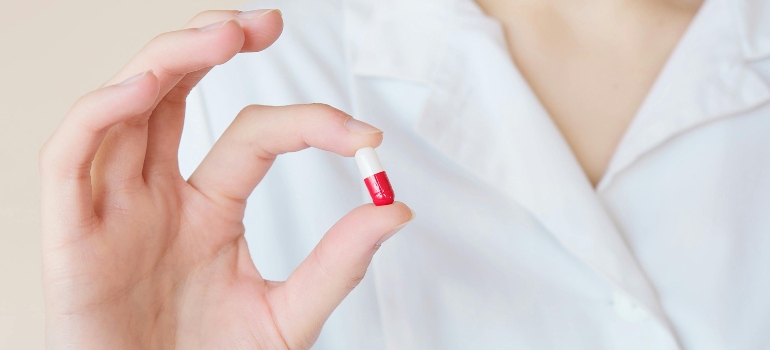 A person holding a white and red pill