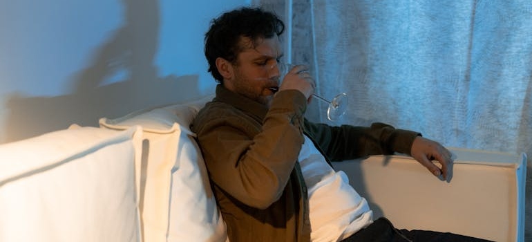 Man sitting on the couch and drinking wine.