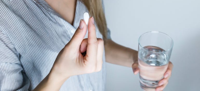 Woman taking an Ativan pill with water.