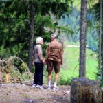 Two elderly people standing in a forest