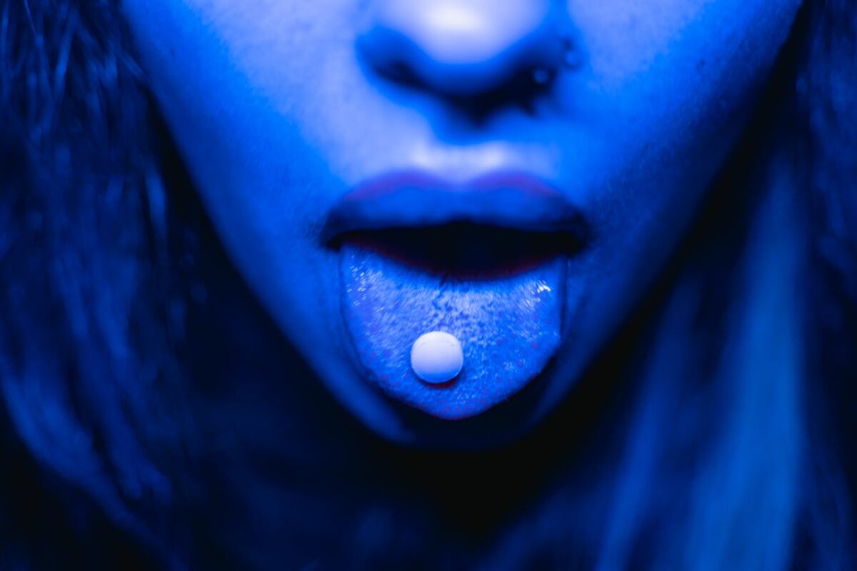 a woman with a pill on her tongue showing the designer drug problem