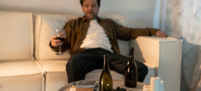 Man sitting on a couch and drinking a glass of wine.