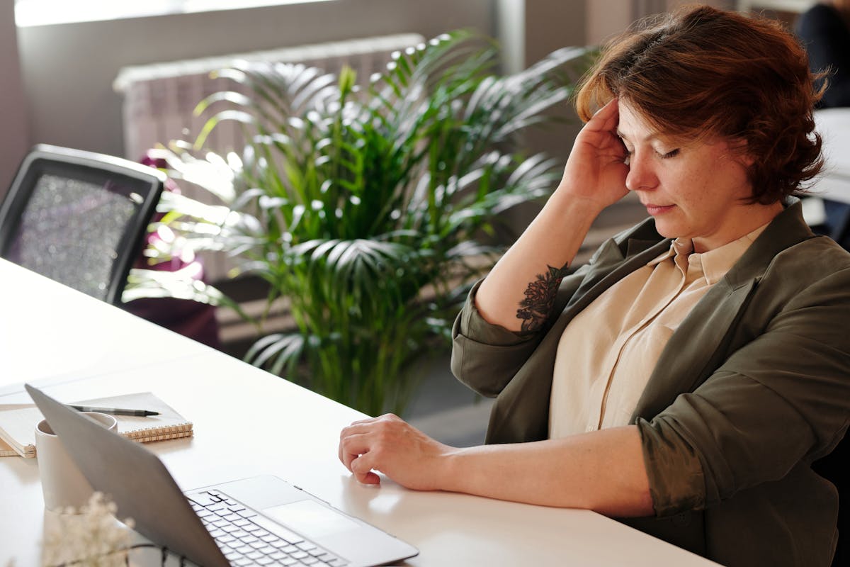 Woman Holding Her Head Wondering Can alcoholism cause chronic headaches