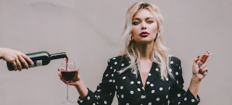 woman standing with wineglass and cigarette