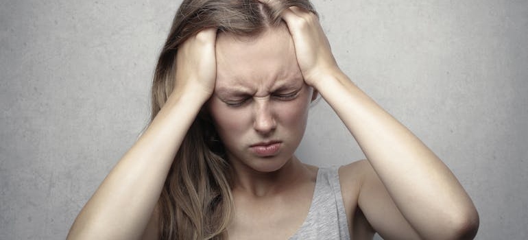 Woman holding her head in pain.