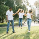 A family of three playing in a park