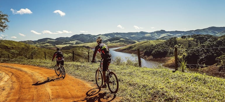 Two men riding bikes on a trail.