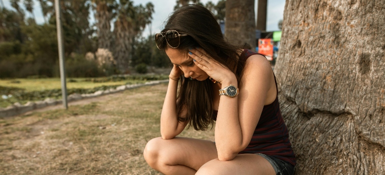 A stressed woman holding her head.