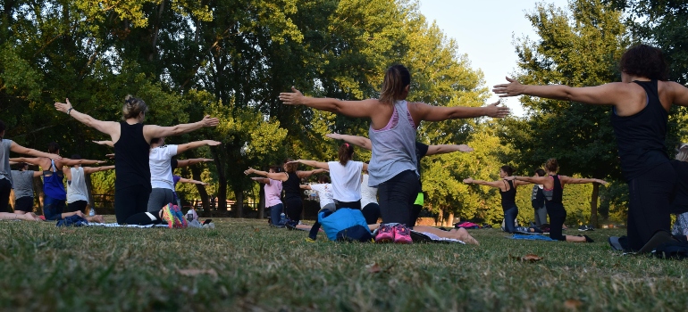 A group of people practicing yoga in a park