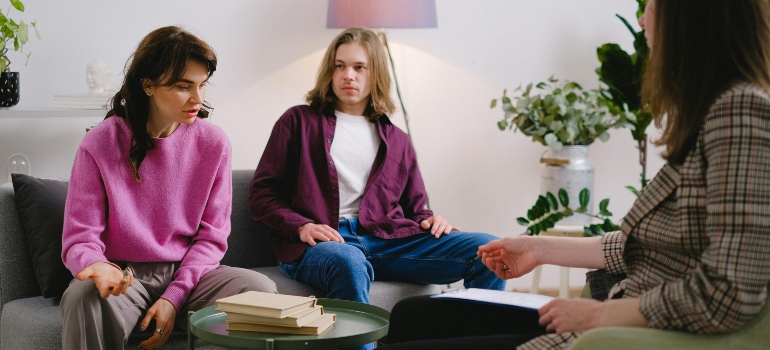 A man and a woman talking to a therapist about risk factors for addiction