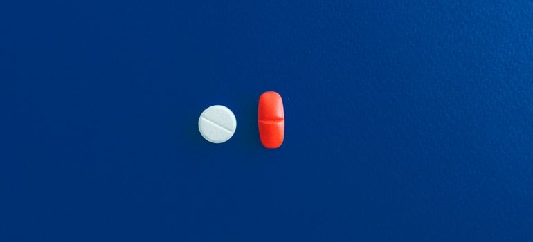 Two different types of pills on a blue background.
