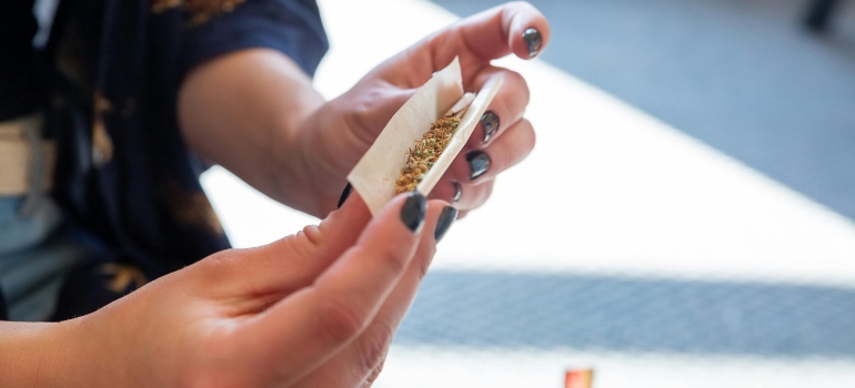 A person rolling salvia into a joint.