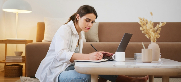 Woman working on her tablet and writing about benefits of quitting weed