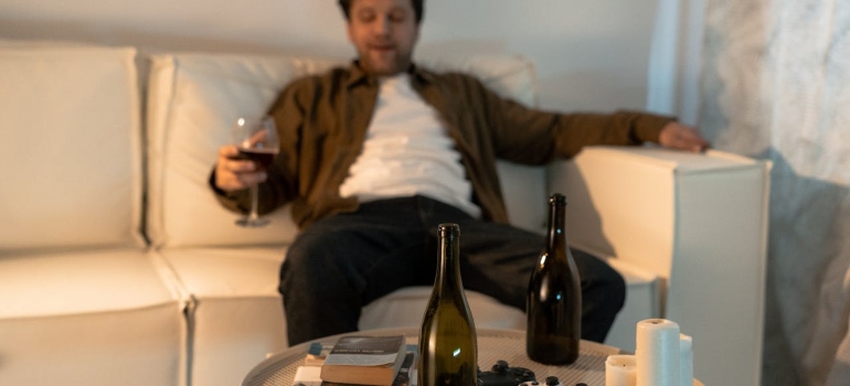 a man sitting on the sofa and drinking alcohol 