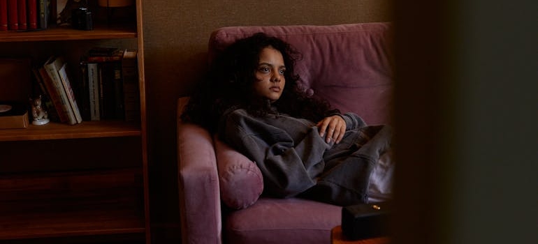 Disheveled woman sitting on a couch.