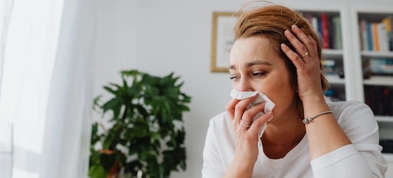 Woman holding a tissue near her nose.