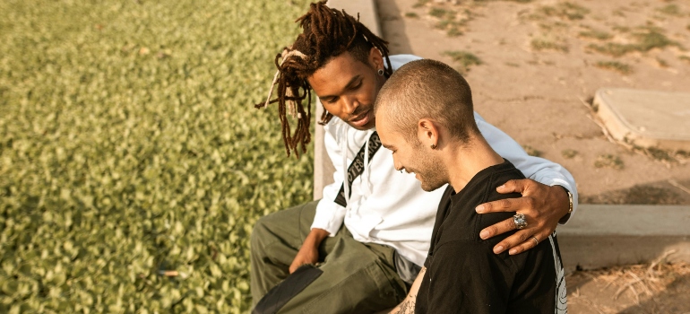 Two friends sitting in a park impact of trauma