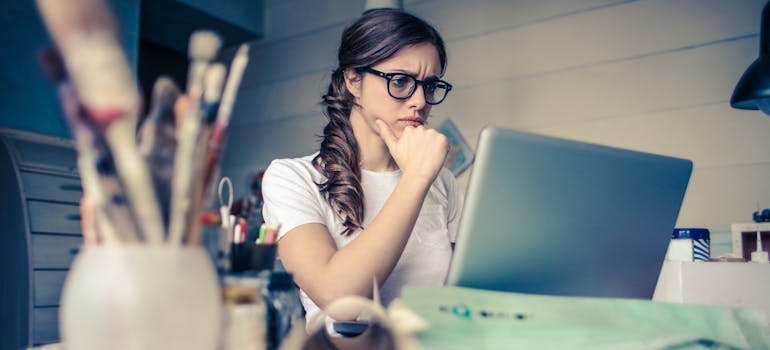 Woman looking at her laptop and focusing.