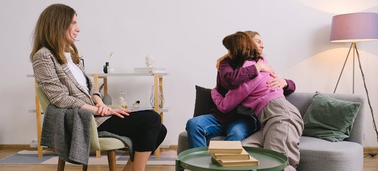 Psychologist watching happy couple embracing on sofa