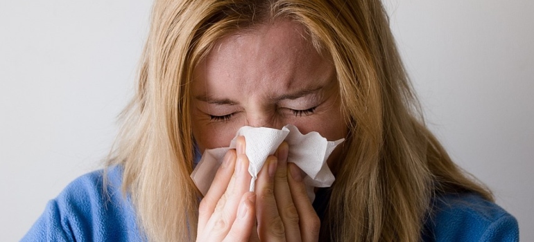 Woman blowing her nose into a tissue.