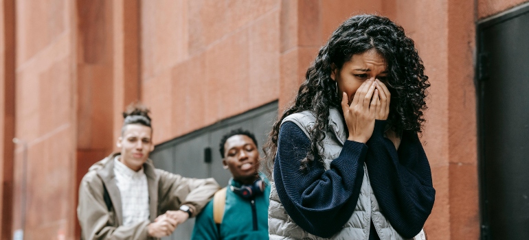 Two college students are gossiping about their female crying college.