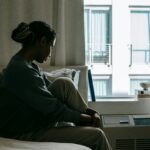 A sad woman on the bed, wondering: Do I Have a Drinking Problem?