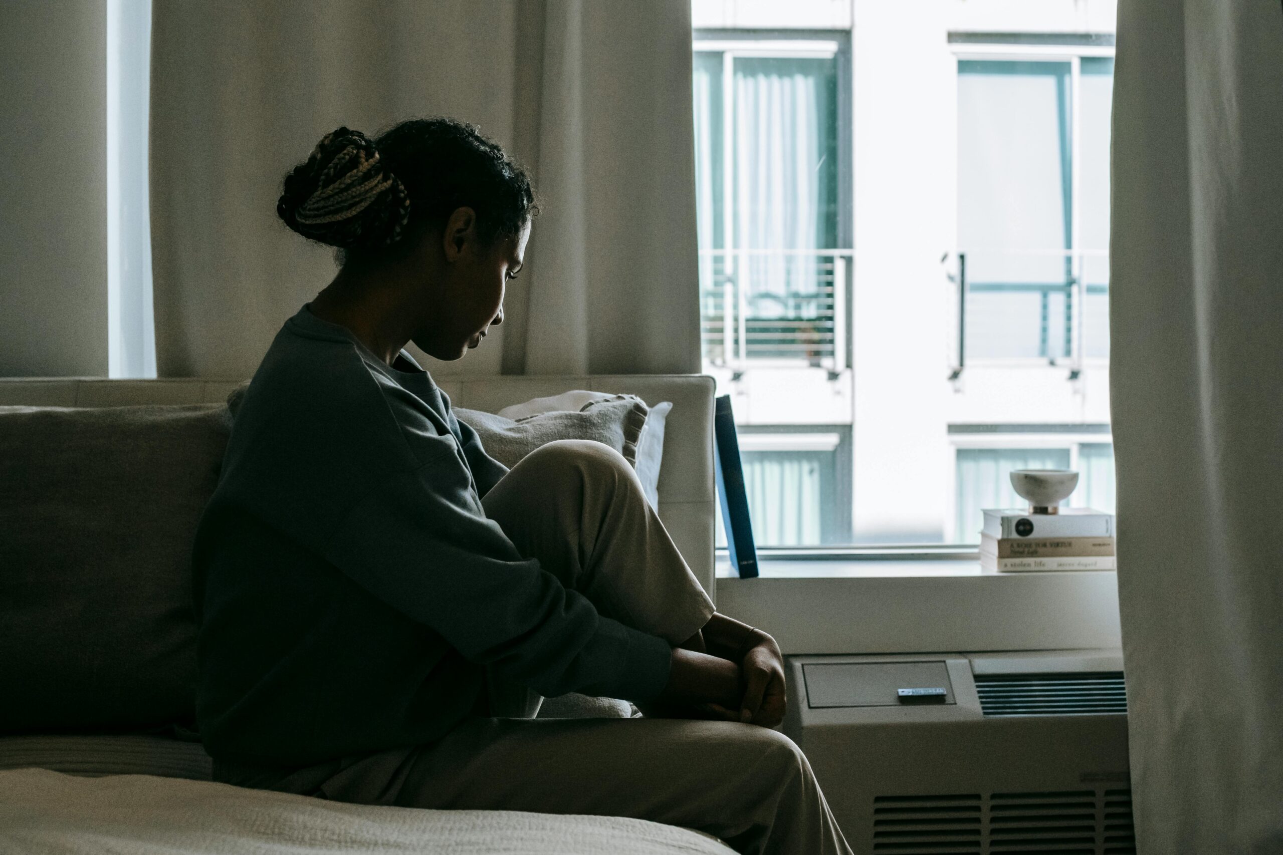 A sad woman on the bed, wondering: Do I Have a Drinking Problem?